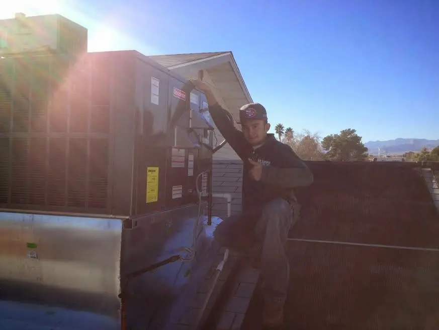 HVAC technician performing Air Duct Repair on a rooftop unit in Winnetka